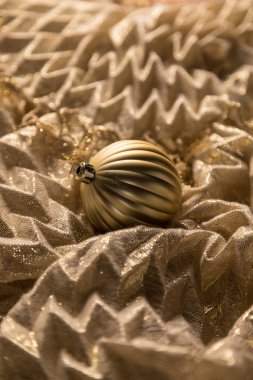 Parlak kumaş üzerine dikey soyut sıcak altın Noel küre biblo