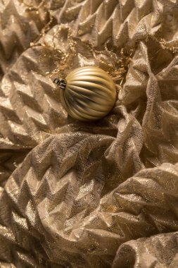 Parlak kumaş arka plan üzerinde dikey altın sıcak Noel biblo. 