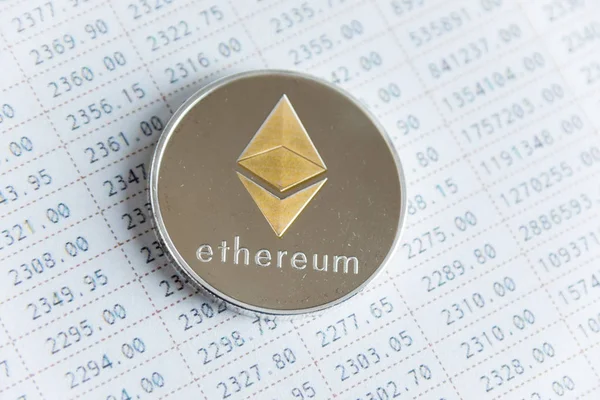 Gold ethereum cryptocurrency coin on numbers graph stock market table. — Stock Photo, Image