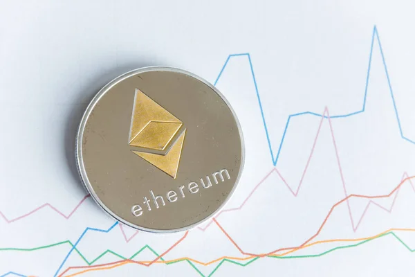 Gold ethereum cryptocurrency coin on rising line graph trading chart — Stock Photo, Image