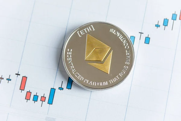 Gold ethereum cryptocurrency coin on candlestick trading chart. — Stock Photo, Image