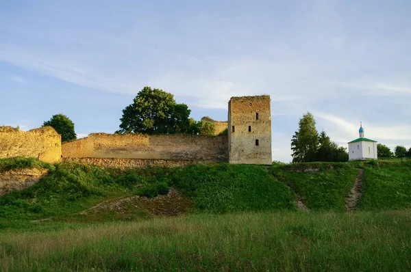 Uma vista das muralhas e torres medievais da fortaleza de Izborsk ao pôr do sol, região de Pskov, Rússia — Fotografia de Stock