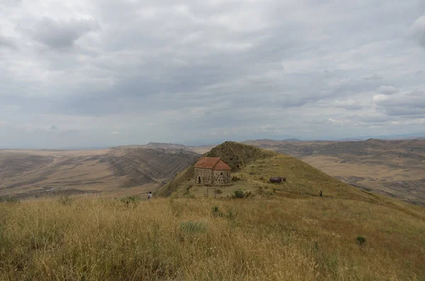 Kis kápolna tetején egy domb közelében David Gareja monostor, a háttérben a nézet félig sivatagi és pusztai lejtőin a hegy Gareja, Grúzia — Stock Fotó