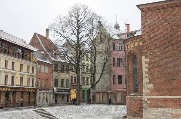 Riga, Latvia - January 1, 2016: Traditional medieval houses in street of Riga old town. Winter and snow.
