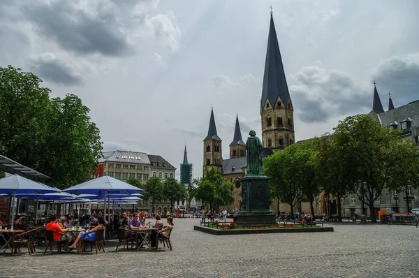 Bonn market square with medieval church The Bonn Minster, statue of Beethoven and tourists in open cafe — Stock Photo, Image