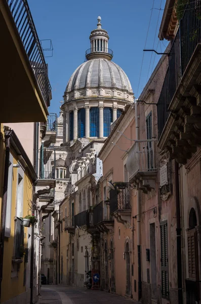 Estrecha calle panorámica en Ragusa, Sicilia, Italia con casas adosadas antiguas y la cúpula de una iglesia visible al final, Patrimonio de la Humanidad por la UNESCO — Foto de Stock