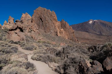 Roques de Garcia 'nın benzersiz kaya oluşumunun arka planında ünlü Pico del Teide volkanı zirvesi gündoğumu, Teide Ulusal Parkı, Tenerife, Kanarya Adaları, İspanya