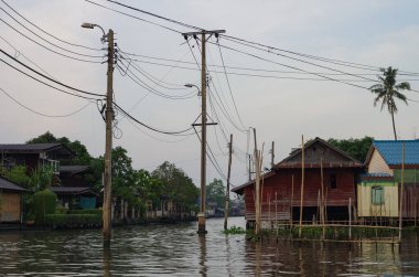 Bangkok 'ta bir klong' da Stilt evleri. Klonglar, Bangkok 'un büyük nehri olan Chao Phraya nehrinden ayrılan kanallardır. Klong bu evlere ulaşmanın tek yolu..