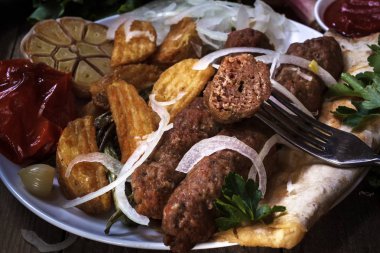 Fried kebap kebap sebze ile sos, soğan ve baharat ızgara. Barbekü. Parça et çatalı üzerinde.