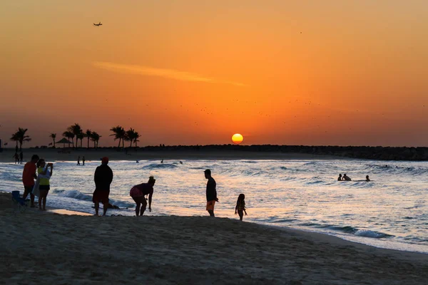 Sahilde günbatımı. Batan güneşin zemin karşı insan siluetleri