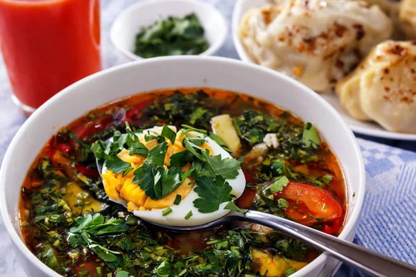 Овощной суп с яйцом и зеленью на фоне томатного сока. Натюрморт — стоковое фото