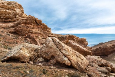 Bulutlar arka planı kırmızı kayalıklarla. Dağ manzarası