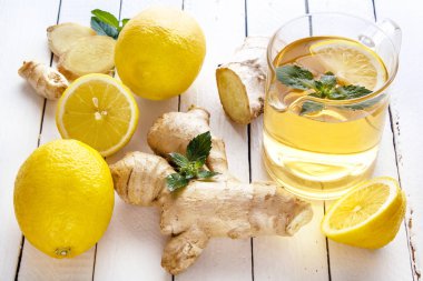 Çay, limon, zencefil, nane beyaz tahtalar üzerinde