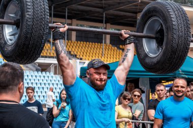 güçlü adam ağır bir halter yükseltir. Halter