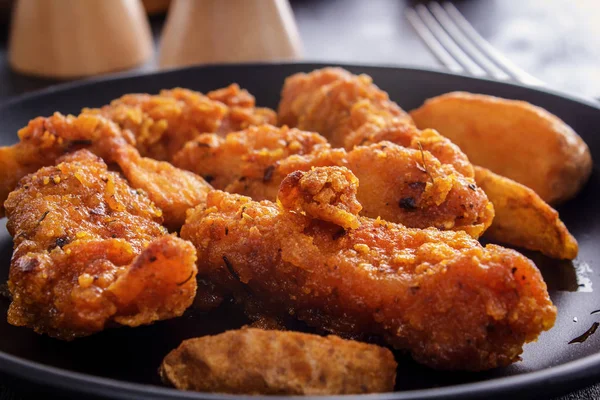 Siyah bir tabakta tavuk nuggets