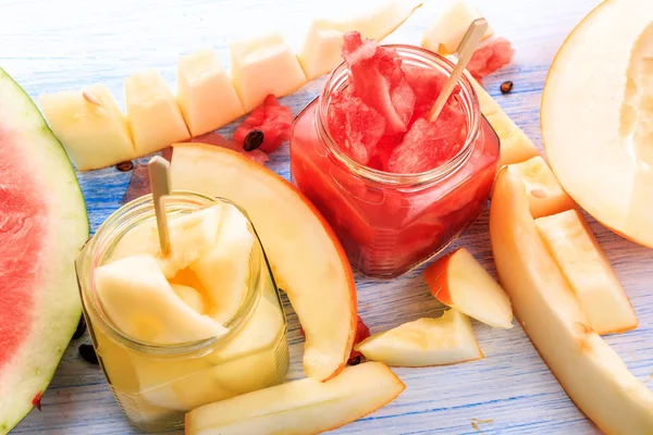 Cóctel de sandía y melón. Sandías frescas y melones cortados en trozos sobre un fondo de madera — Foto de Stock