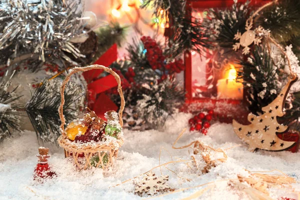 Pequenas garrafas de vidro multicores de Santa em uma cesta de vime com presentes no fundo de uma lanterna vermelha e decorações de Ano Novo. Luz suave — Fotografia de Stock