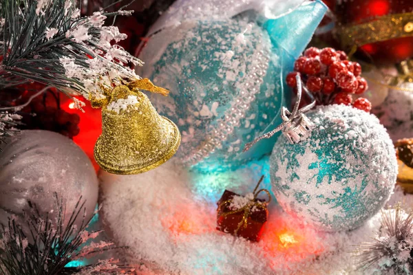 Gouden Christmas bell opknoping op een tak samen met kerstversiering. veelkleurige lichten, uitstraling, briljante klatergoud — Stockfoto