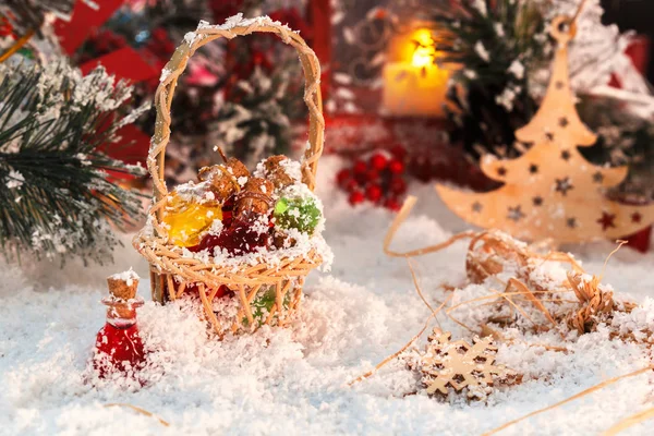 Pequenas garrafas de vidro multicoloridas de Santa em uma cesta de vime com presentes no fundo de uma lanterna vermelha e decorações de Ano Novo — Fotografia de Stock