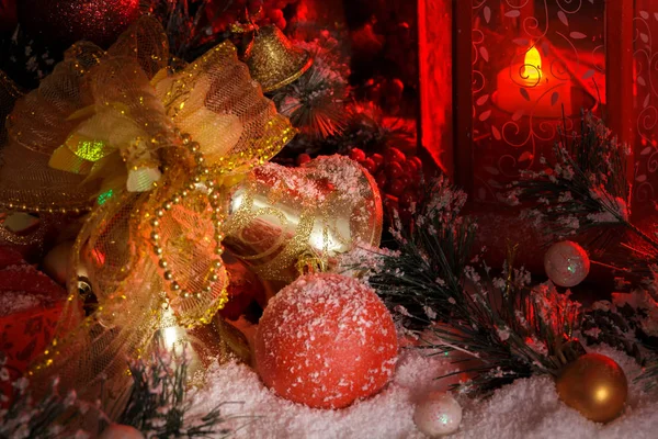 Altın christmas bells ve kırmızı bir fener ışığında Noel oyuncaklar — Stok fotoğraf