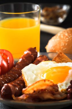 Tam geleneksel İngiliz kahvaltısı kızarmış yumurta, sosis, fasulye, mantar, pastırma, taze meyve suyu ve ekmek olduğunu