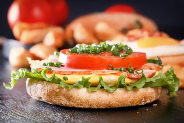 Kızarmış yumurta, pastırma, domates, yeşillik ile sandviç. Patates kızartması ve mantar kahvaltı. Siyah arka plan