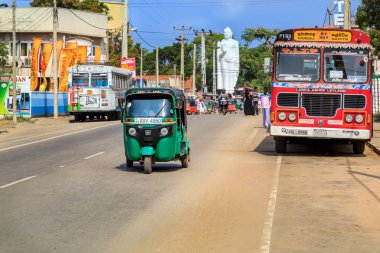 Kalpitiya, Sri Lanka - 2 Ocak 2018. Tuk-Tuk ve otobüs sürmek köy alışveriş caddesi üzerinde tipik bir günde