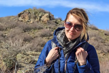 dağ taş ve mavi gökyüzü bulutlu bir arka plan karşı gelen bir sırt çantası ile kız iner