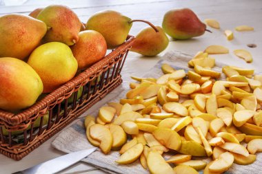 armut ve dilimlenmiş armutlar Tekstil peçete ile beyaz ahşap kurullarında grubudur. Ev ödevi