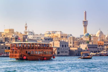 Dubai, Birleşik Arap Emirlikleri - 16 Ocak 2018. Geleneksel ahşap gemi turist taşıyan şehrin eski kesiminde Bay Creek boyunca güneşli bir günde