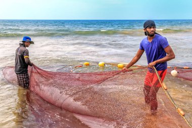 Colombo, Sri Lanka - 14 Ocak 2018. İki balıkçı denizden kıyıya balık ile bir trol güneşli bir günde elde