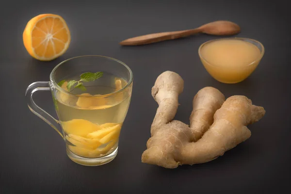 Thé au gingembre au citron, miel et menthe sur une table en bois gris — Photo