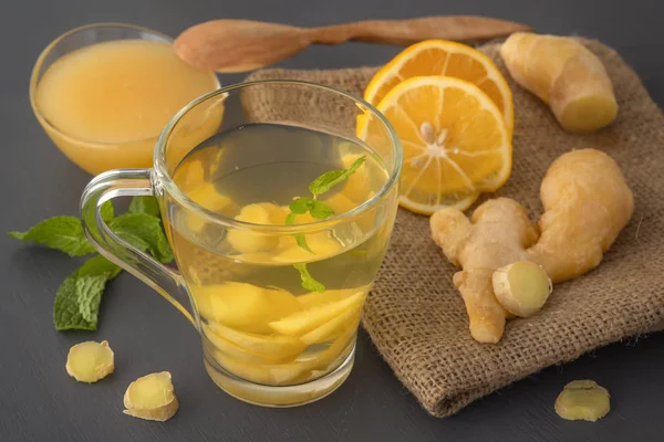 Thé au gingembre au citron, miel et menthe sur une table en bois gris. Gros plan — Photo