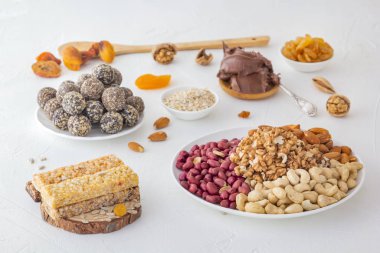 Ceviz, tohum ve çikolata ezmesinden elde edilen spor yiyecekleri - sebze doğal proteini, kurutulmuş meyve karışımı, parlak bir masa üzerinde çeşitli fındık ve tohumlar.