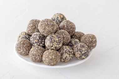 Fındık, kakao ve bal ile sağlıklı organik enerji ısırıkları. Spor yemekleri, beyaz arka planda vejetaryen çiğ yiyecekler. Boşluğu kopyala