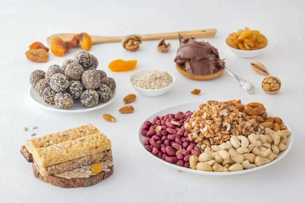 Ceviz, tohum ve çikolata ezmesinden elde edilen spor yiyecekleri - sebze doğal proteini, kurutulmuş meyve karışımı, parlak bir masa üzerinde çeşitli fındık ve tohumlar.