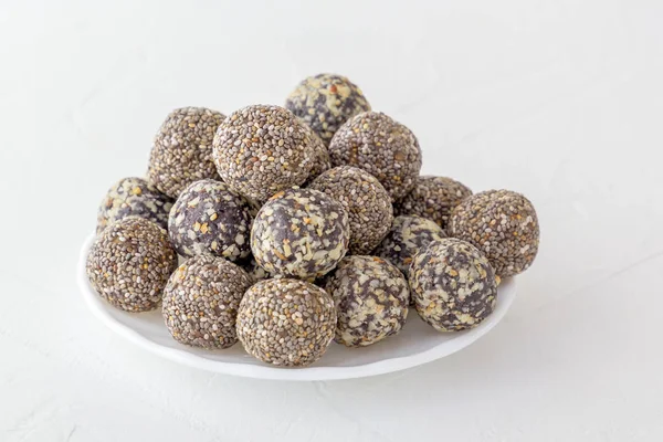 Fındık, kakao ve bal ile sağlıklı organik enerji ısırıkları. Spor yemekleri, beyaz arka planda vejetaryen çiğ yiyecekler. Boşluğu kopyala