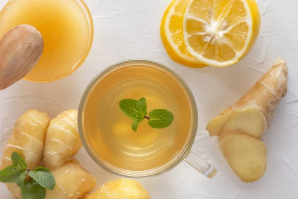 Tea gyömbérrel, mentával, citrommal és mézzel egy fehér fa asztalon. Közelkép. Felülnézet — Stock Fotó