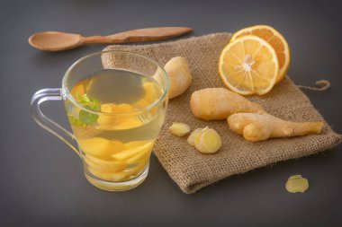 Gri ahşap bir masada limonlu zencefil çayı ve nane şekeri. Yakın plan.