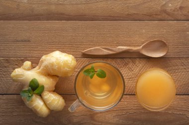 Limonlu zencefil çayı, bal ve ahşap bir masada nane. Uzayı kopyala Üst görünüm