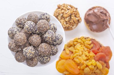 Doğal sağlıklı çiğ enerji ısırıkları ve beyaz bir masada fındıklı kurutulmuş meyve karışımı. Üst Manzara. Yakın plan.