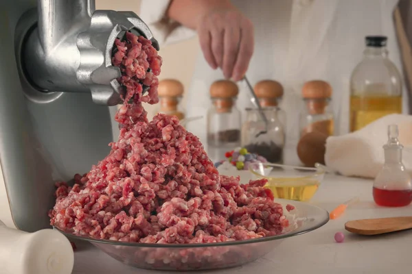 Kıyma makinesinden çıkan kıyma, bir kimya laboratuarının cam kaplamasına çarpar. Yapay et üretimi. Yakın plan.