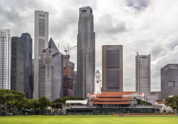 Singapore - January 8, 2020. City cricket club and an old clock tower against the backdrop of modern Downtown skyscrapers — Stock Photo, Image