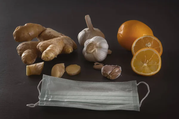 Zencefil, sarımsak, limon ve tıbbi maske. Karanlık bir masadaki viral enfeksiyondan ve soğuk algınlığından korunmak için. Alçakgönüllülük. Yaklaş. Boşluğu kopyala