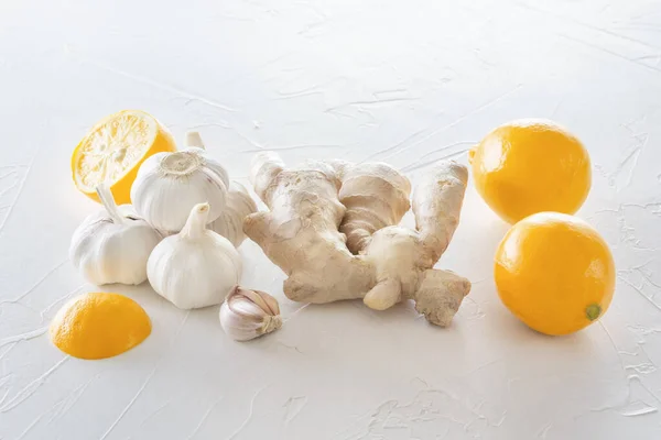 Ginger, garlic and lemon - a means to protect against viral infection and colds on a light wooden table. Copy space