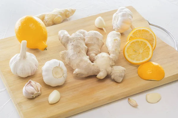 Ginger, garlic and lemon - a means to protect against viral infection and colds on a light wooden table. Close-up