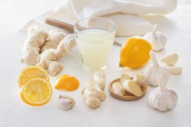 Zencefil, sarımsak, limon, kavanozda kurumuş papatya çayı ve zencefil çayı. Hafif ahşap bir masada viral enfeksiyonlara ve soğuk algınlığına karşı koruma amaçlı..