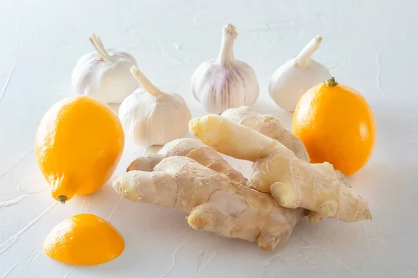 Ginger, garlic and lemon - a means to protect against viral infection and colds on a light wooden table. Close-up