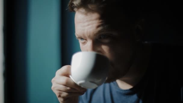 The young man has coffee and looks out of the window. — Stock Video