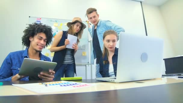 Cuatro amigos trabajan juntos en la oficina — Vídeos de Stock